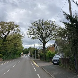 a car driving down a street next to trees
